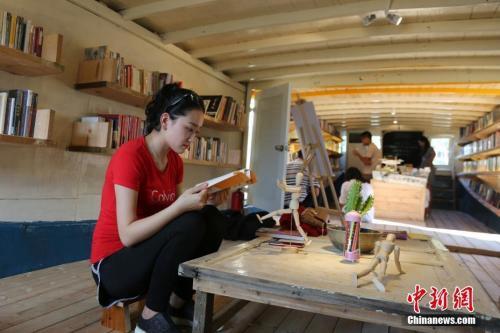资料图：一位女读者在翻看书籍。中新社记者 尹海明 摄
